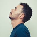 Close-up side portrait of a young man with closed eyes in a contemplative pose.